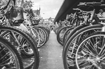 grayscale photo of bicycle parked on the side of the road
