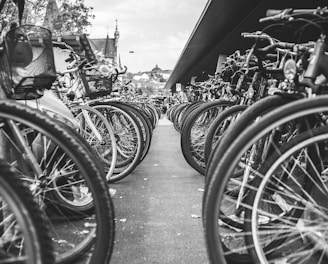 grayscale photo of bicycle parked on the side of the road