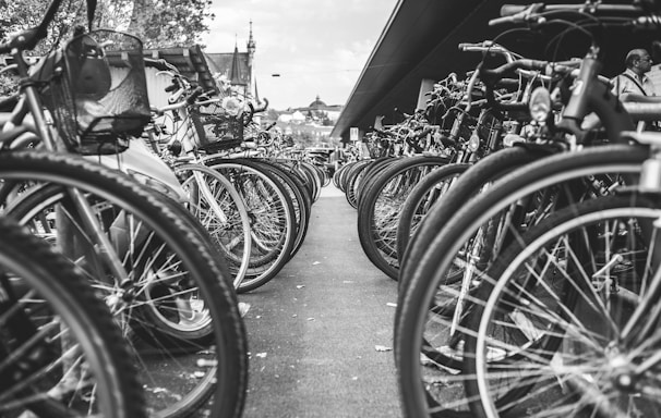 grayscale photo of bicycle parked on the side of the road