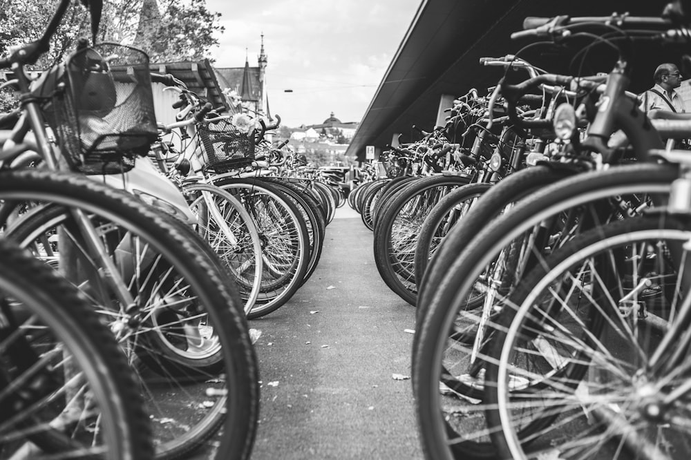 foto in scala di grigi di bicicletta parcheggiata sul ciglio della strada