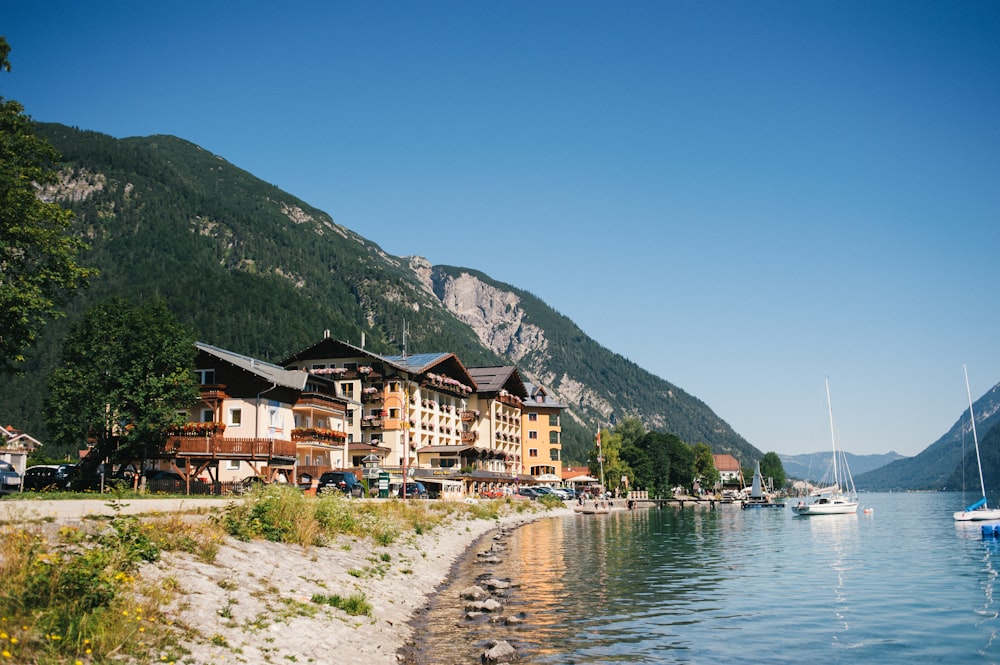 houses near body of water and mountain during daytime