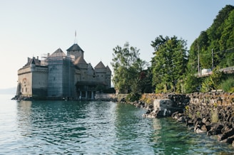 white and gray concrete building near body of water during daytime
