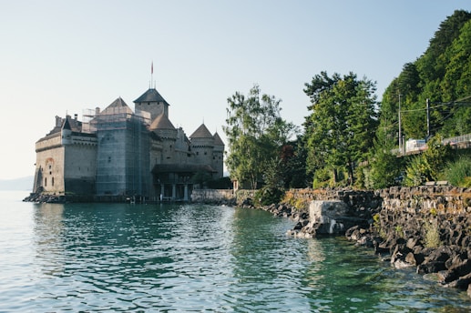 white and gray concrete building near body of water during daytime