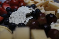 A selection of gourmet cheeses arranged with fresh fruits.