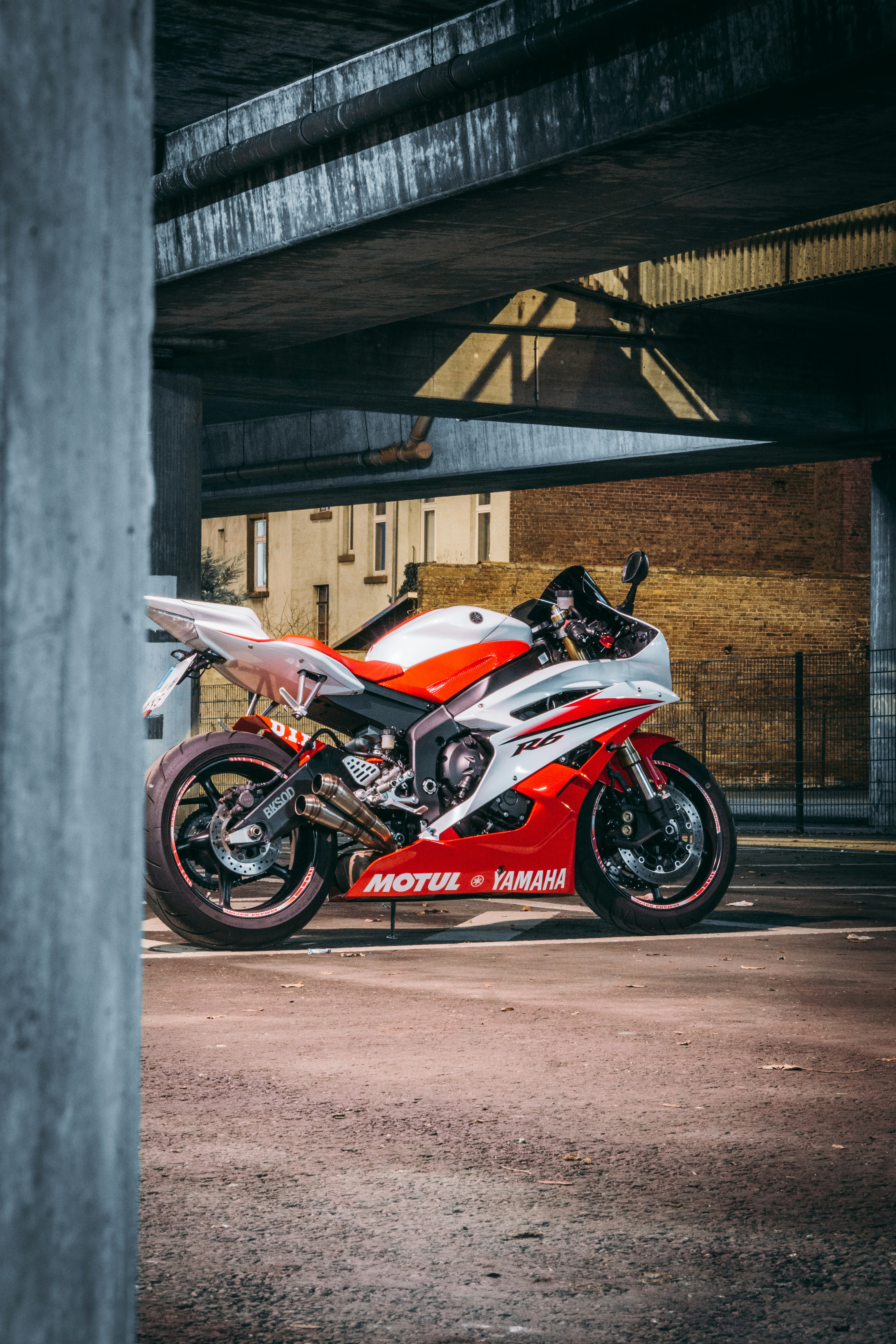 赤と白のスポーツ バイクが灰色のコンクリートの壁の横に駐車の写真 Unsplashで見つけるドイツの無料写真