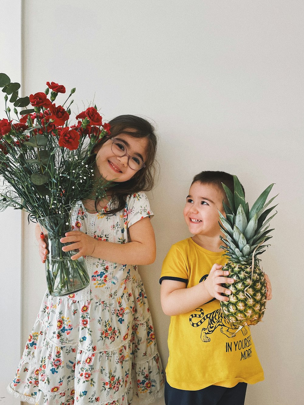 girl in yellow and white polka dot dress holding bouquet of red roses