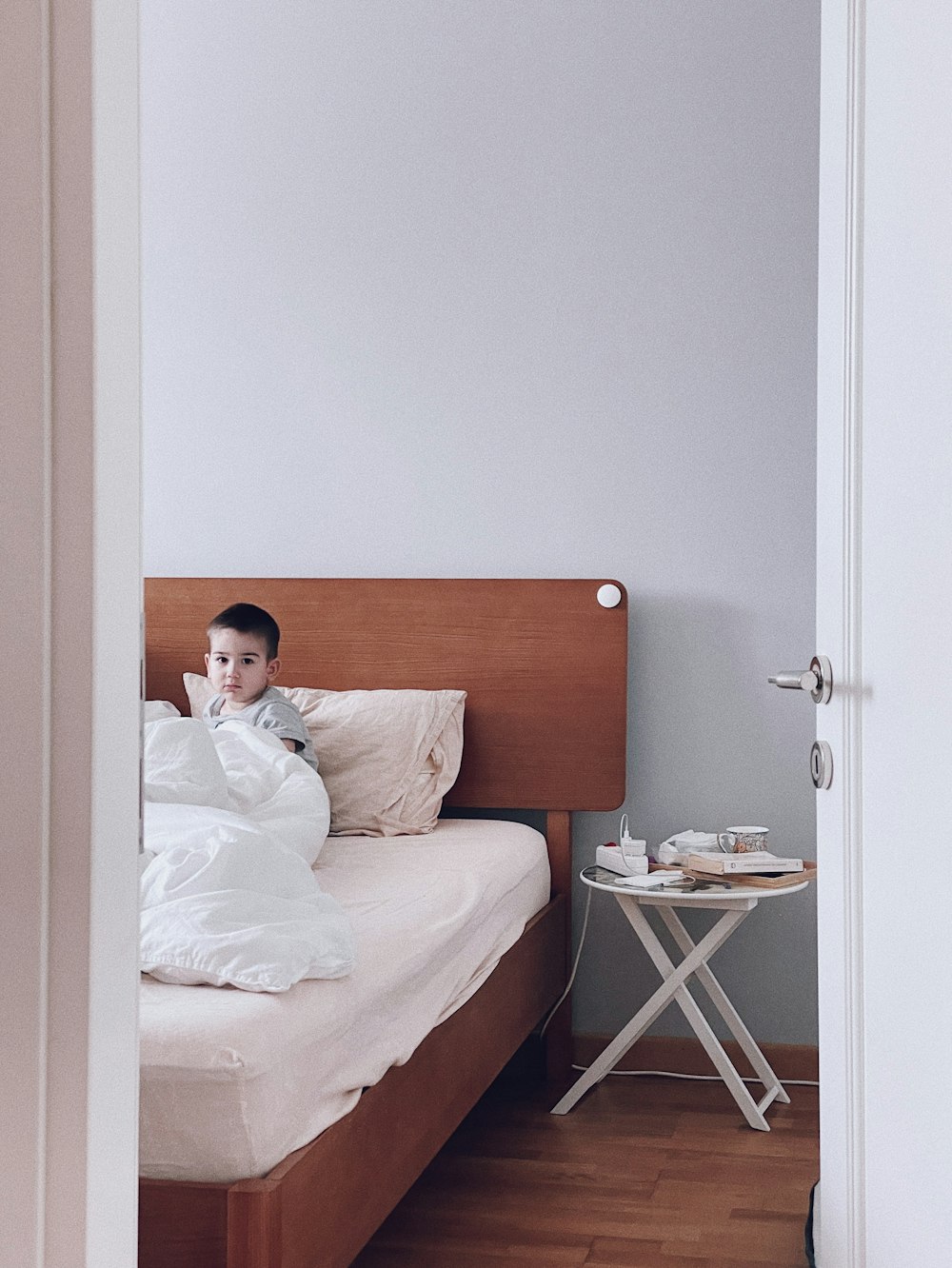 bambino in camicia bianca sdraiato sul letto