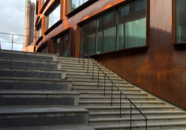 brown concrete staircase with stainless steel railings