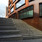 brown concrete staircase with stainless steel railings