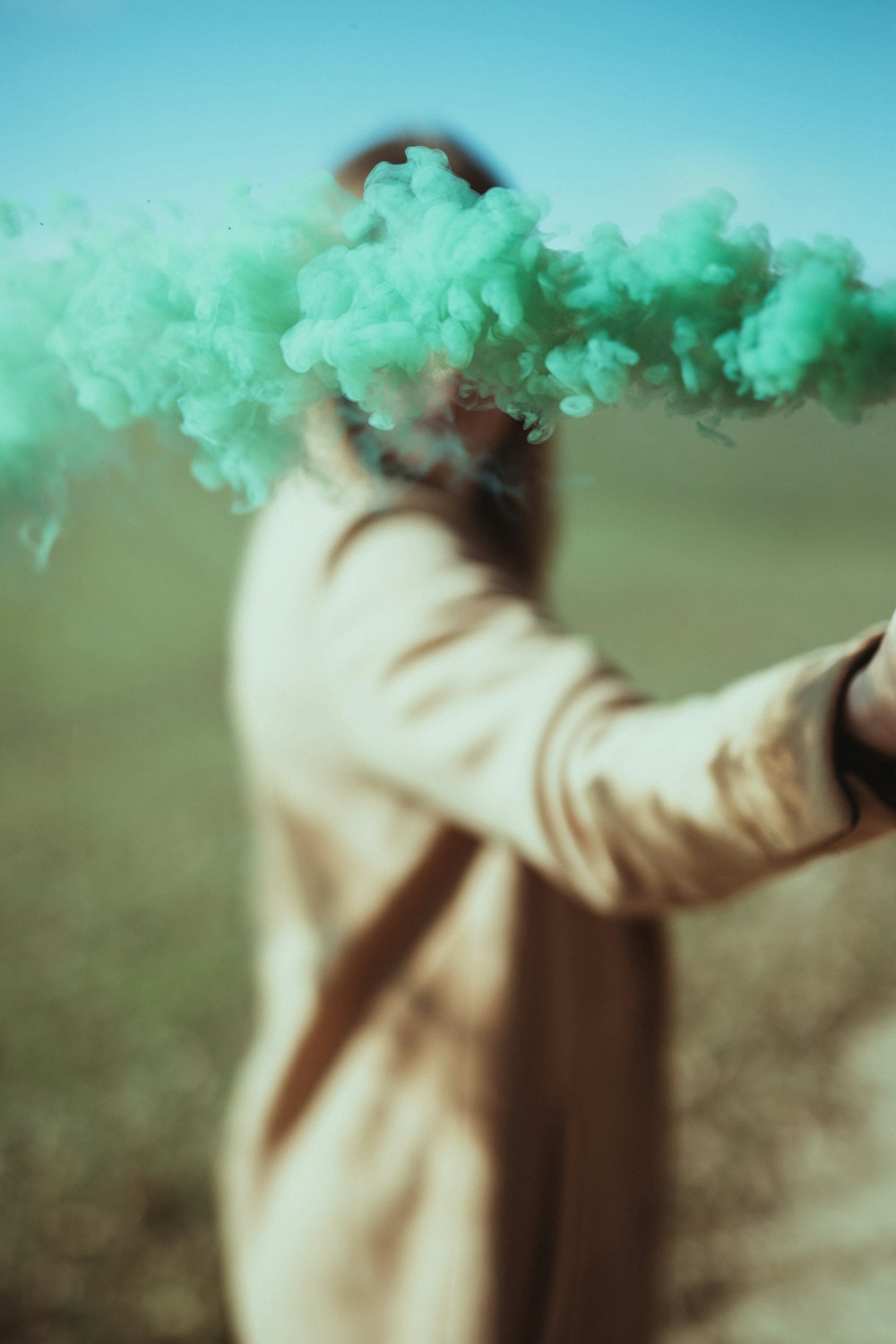 person in white long sleeve shirt holding green powder