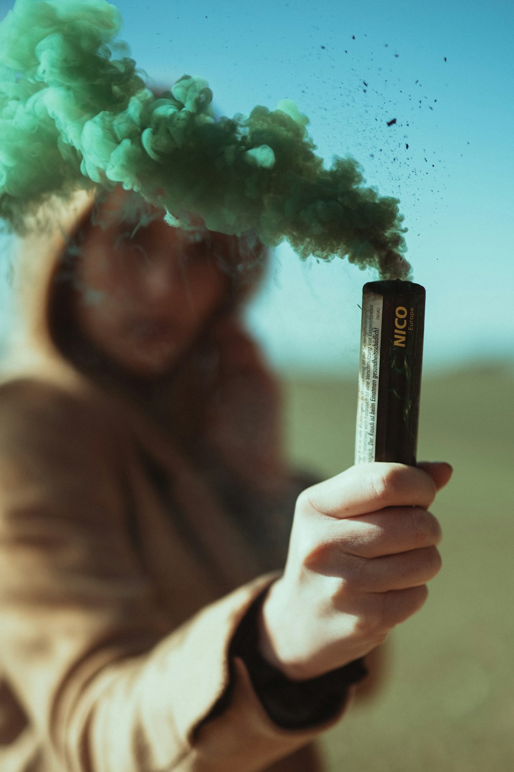 woman holding green smoke stick