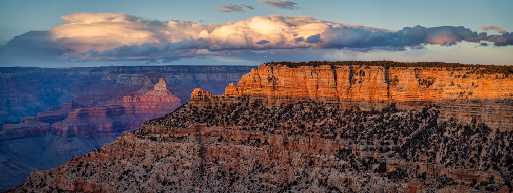 brown rock formation under white clouds during daytime