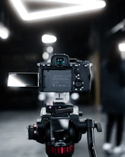 A focused YouTube reviewer filming a product demo with professional lighting and camera setup.