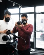 Volunteers cleaning and testing cameras in a bright workshop.