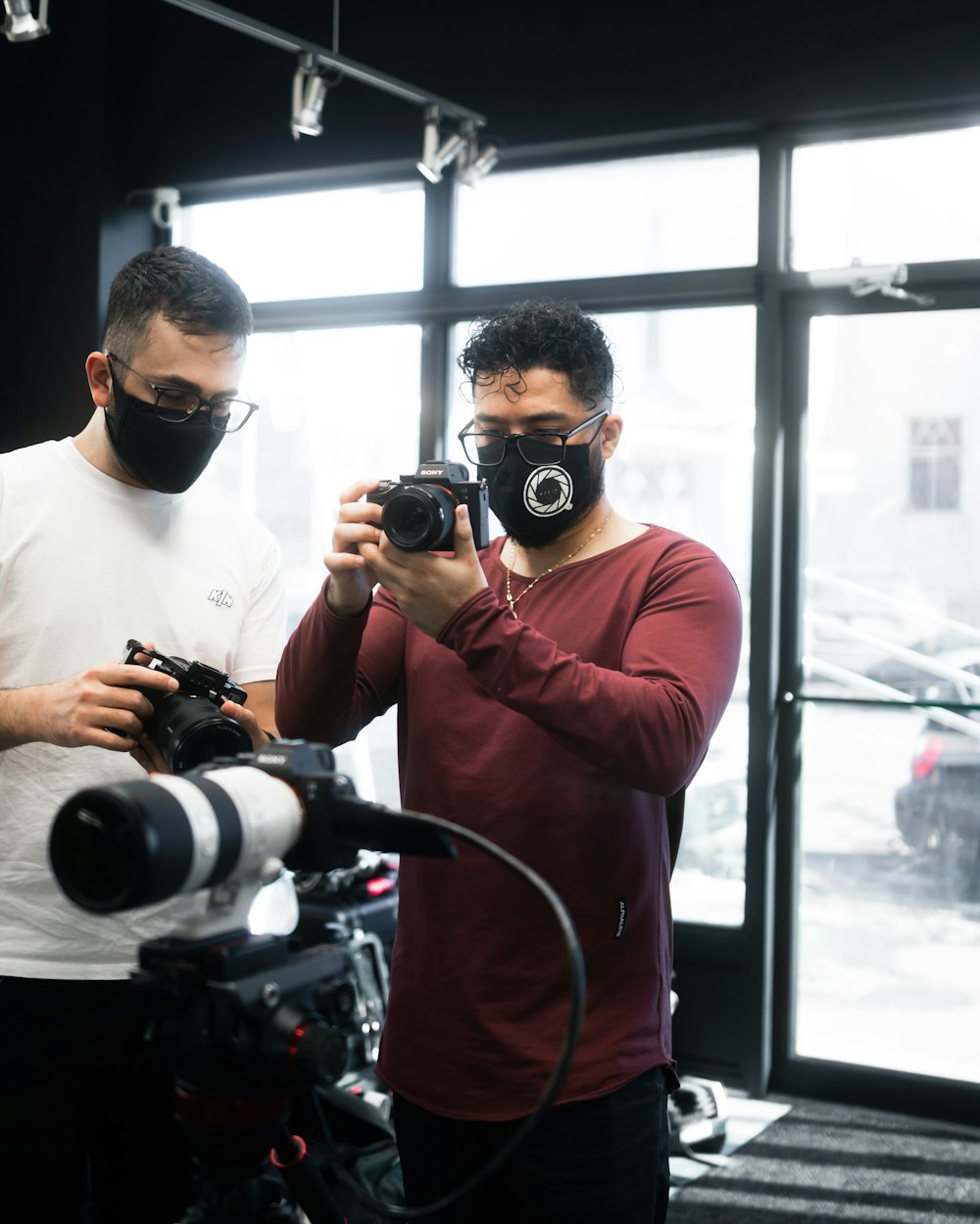 man in red long sleeve shirt holding black dslr camera