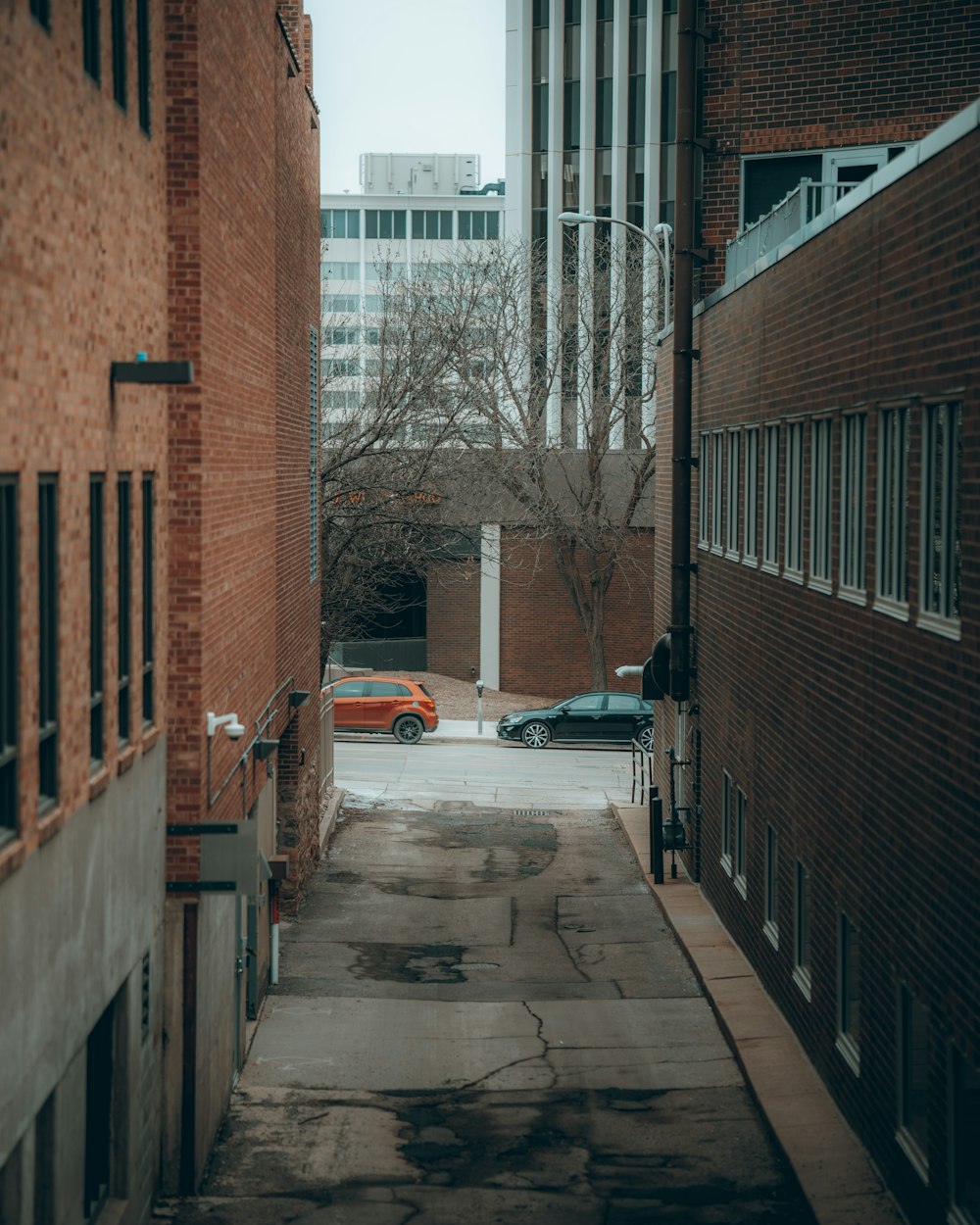 white sedan parked beside brown concrete building during daytime