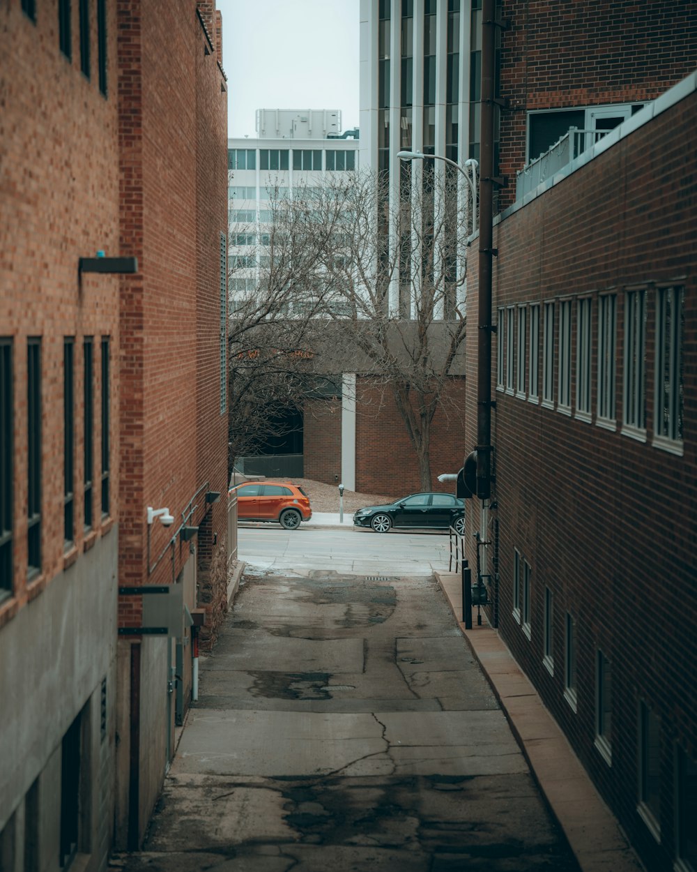 Une berline blanche garée à côté d’un bâtiment en béton brun pendant la journée