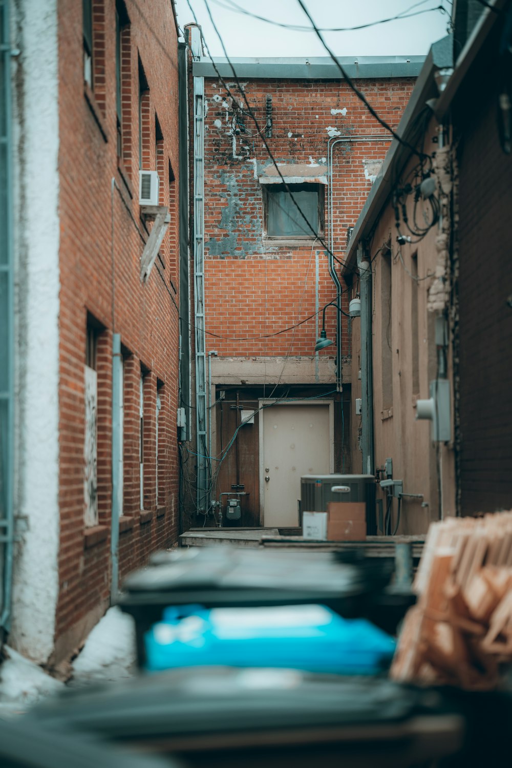 blue car parked beside brown brick building during daytime