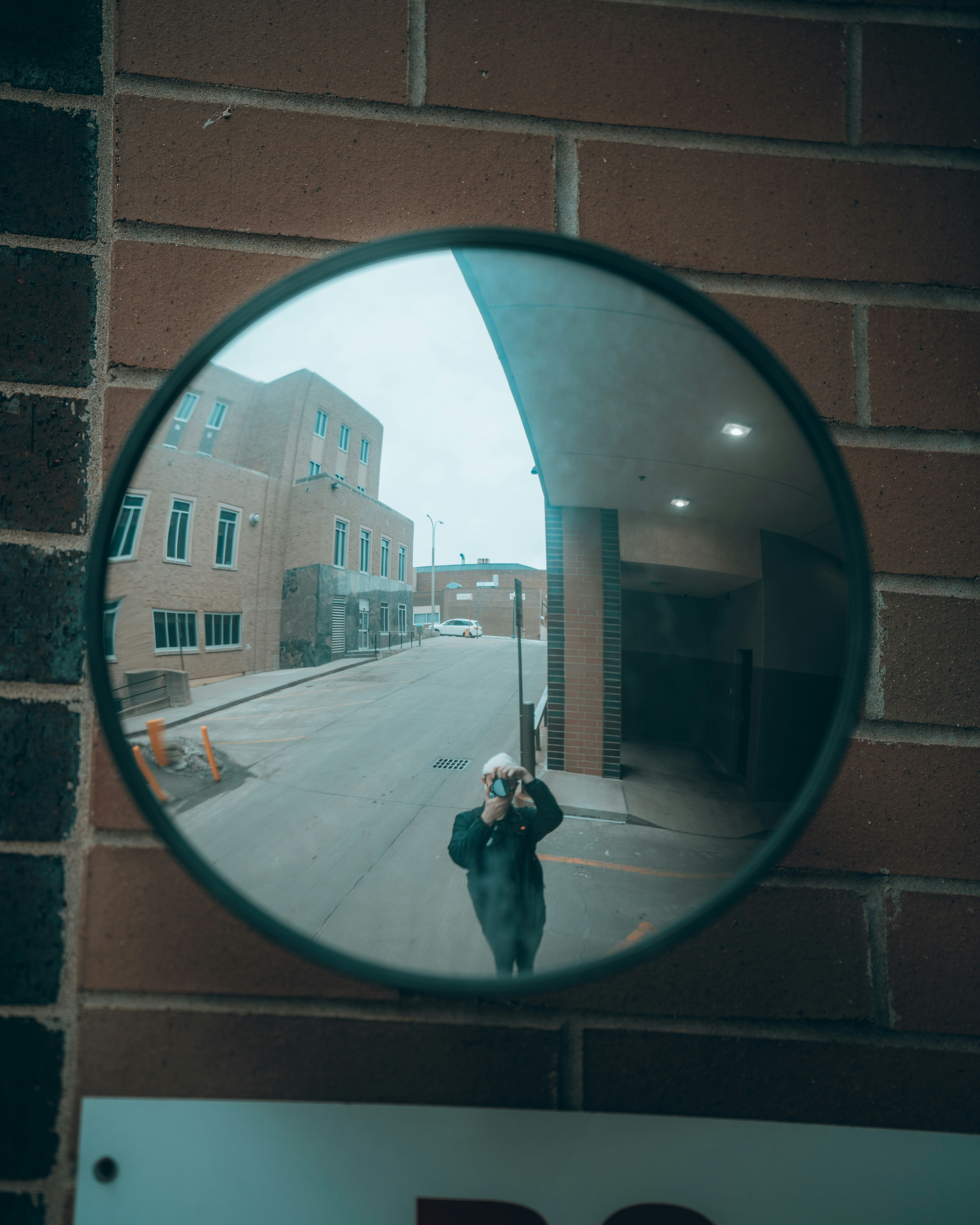 black round mirror on brown brick wall