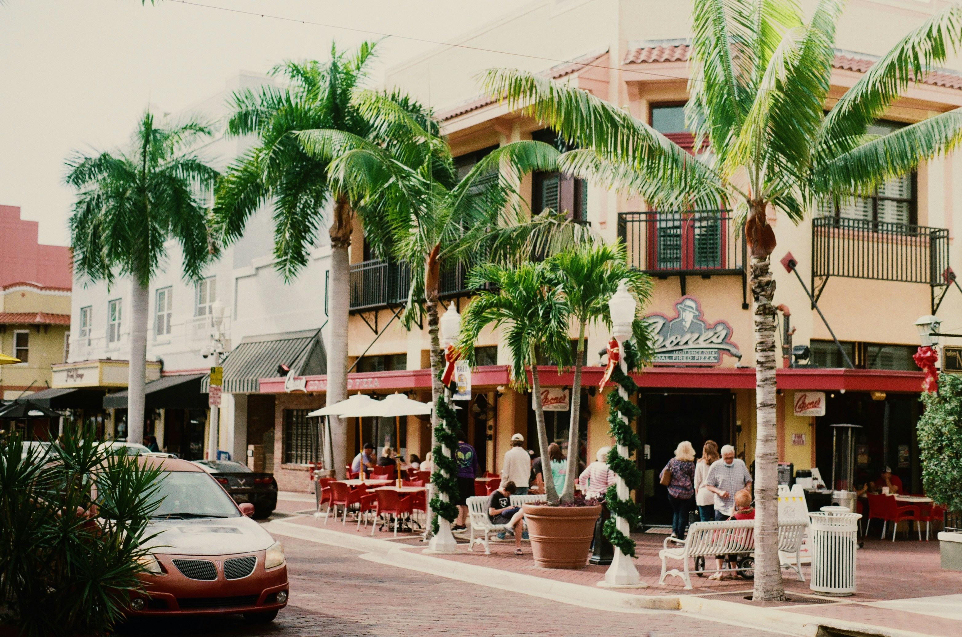 people sitting on chairs near red and white concrete building during daytime