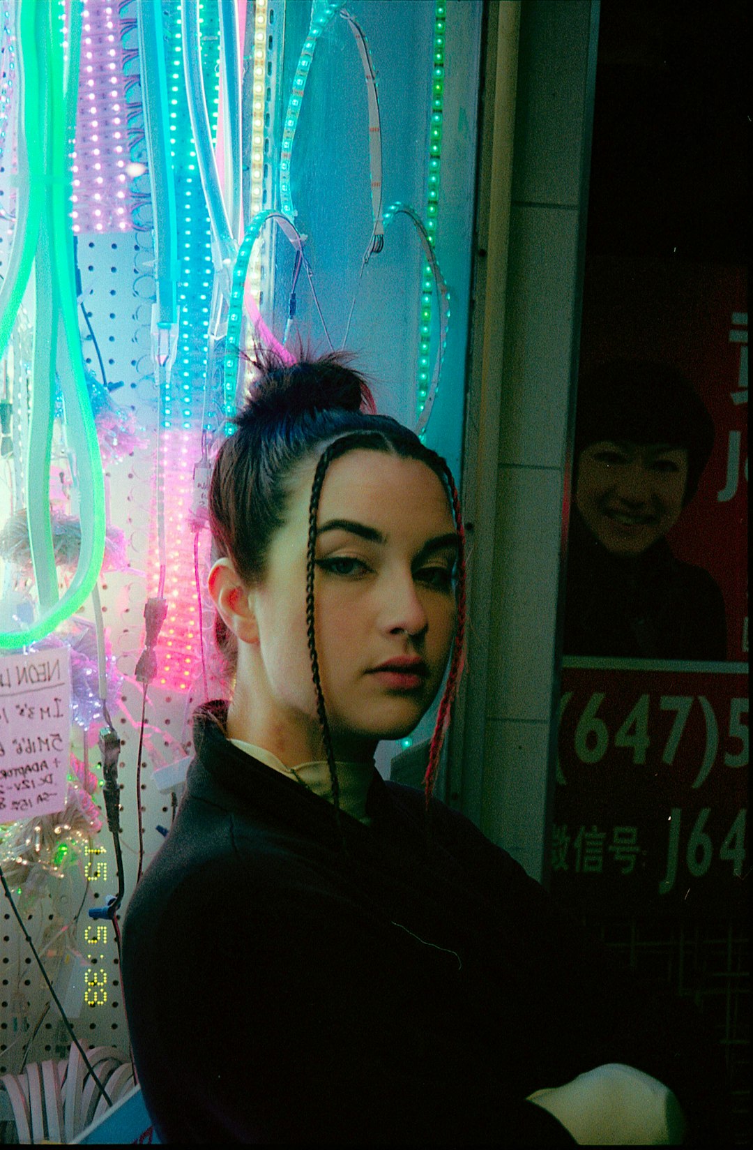 woman in black hoodie standing near glass window