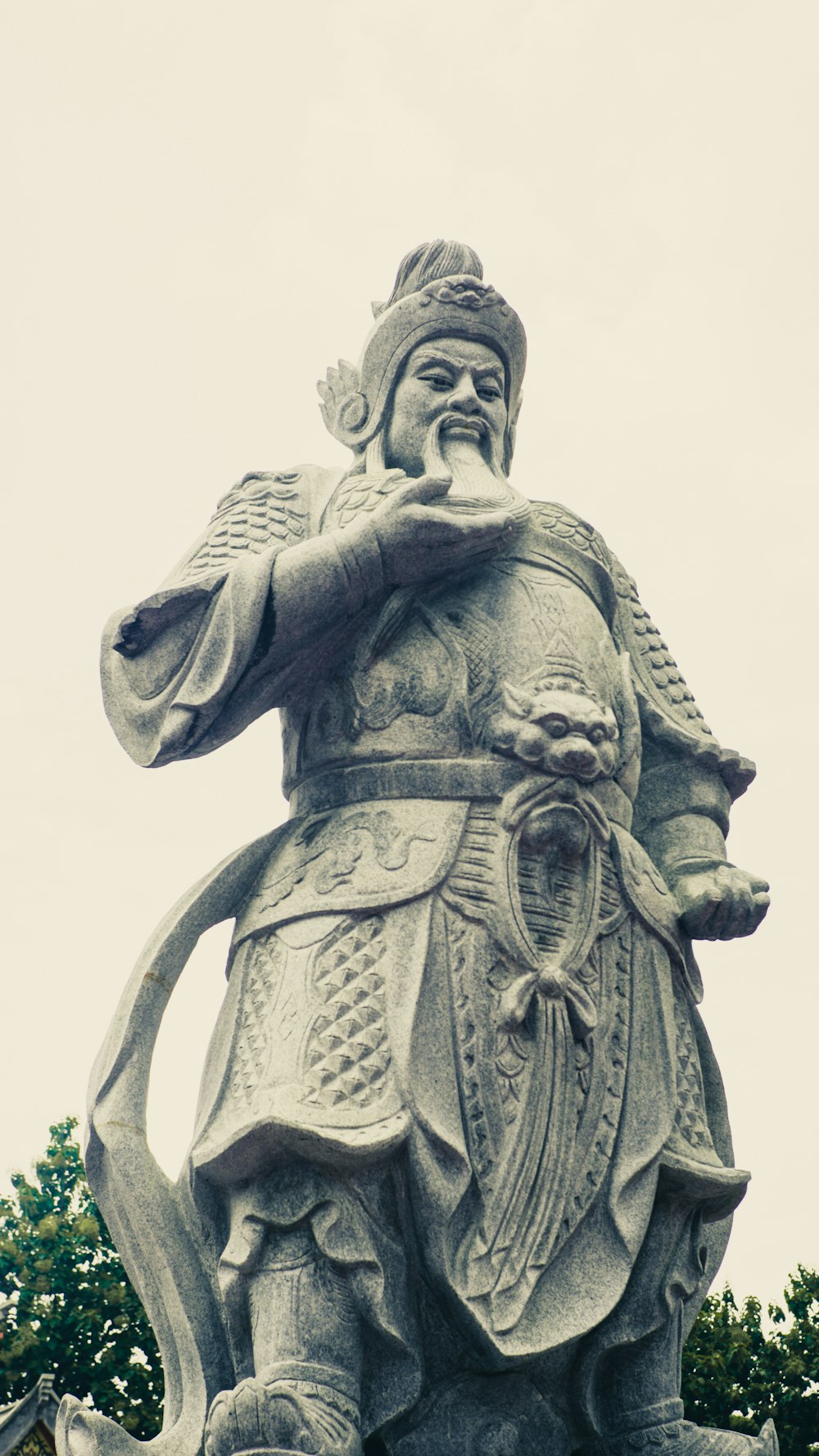 mulher que segura a foto da escala de cinza da estátua do livro