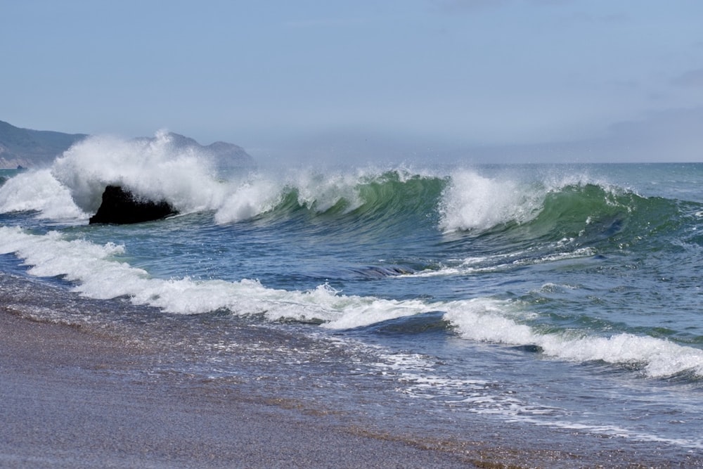 ocean waves crashing on shore during daytime