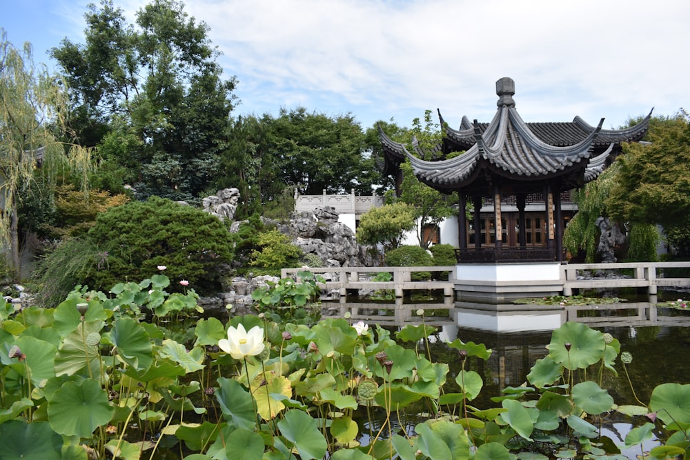 black and white temple surrounded by green trees under white clouds during daytime