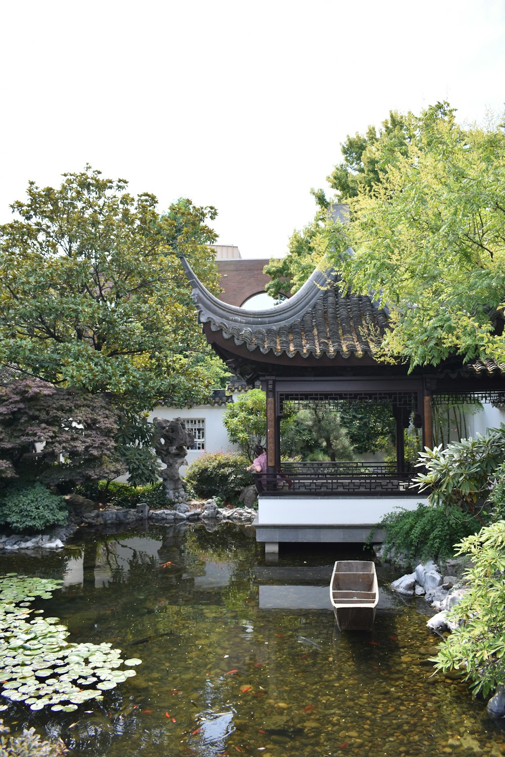 brown wooden gazebo near green trees and river during daytime