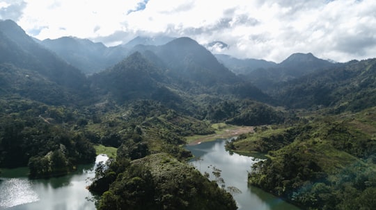 green mountains and river under white clouds during daytime in Santa Cruz de Yojoa Honduras
