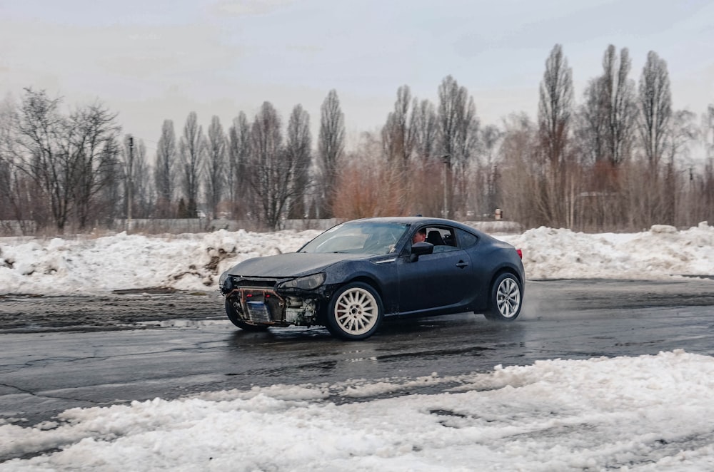 black bmw coupe on snow covered ground during daytime