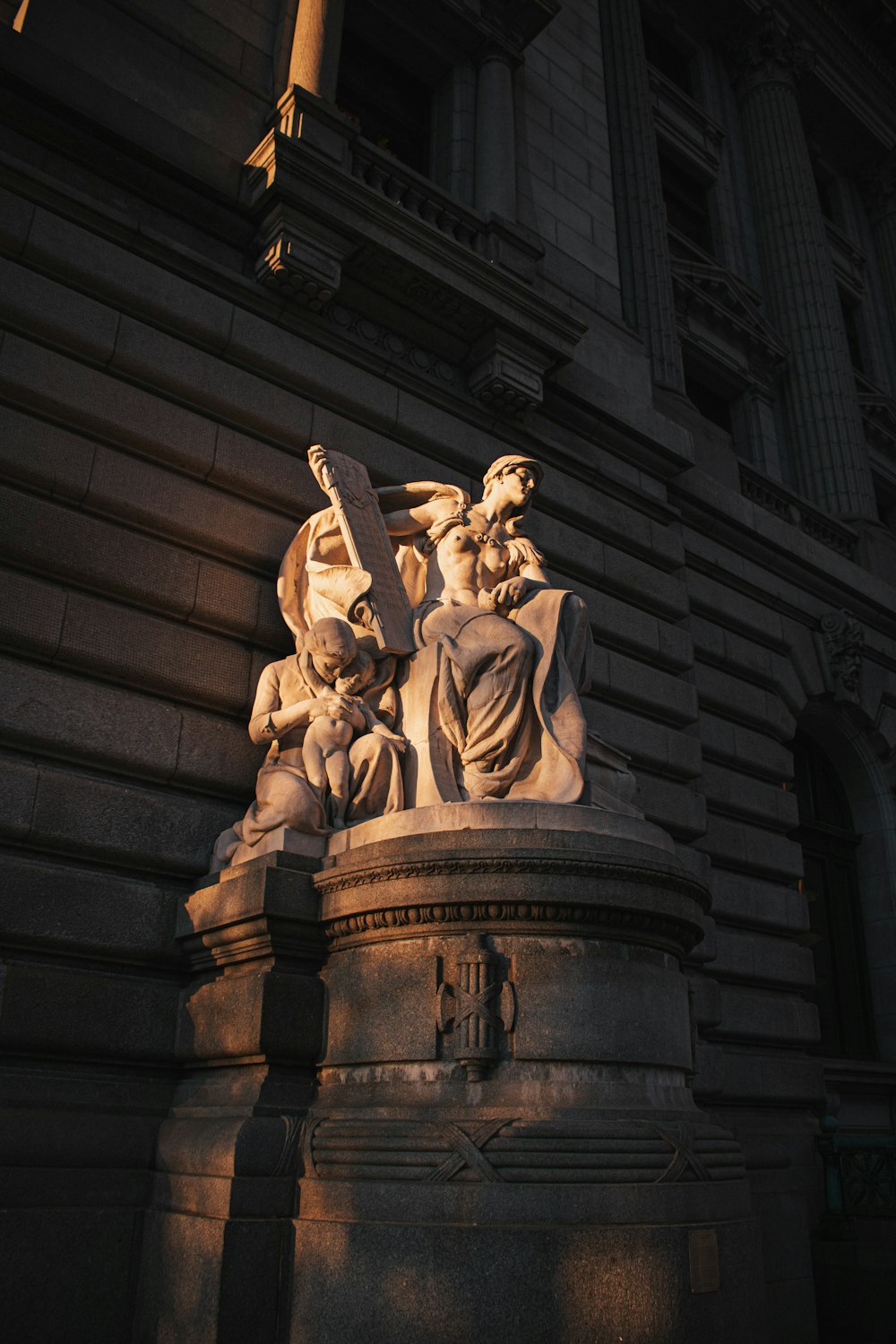 man in coat statue on top of brown concrete building