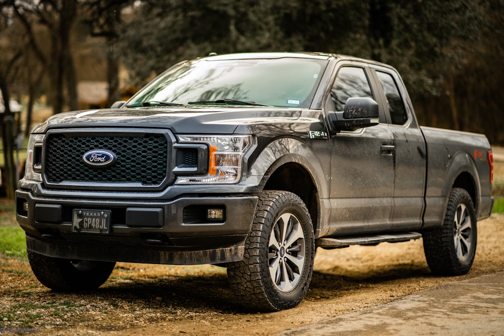 black ford suv on dirt road during daytime