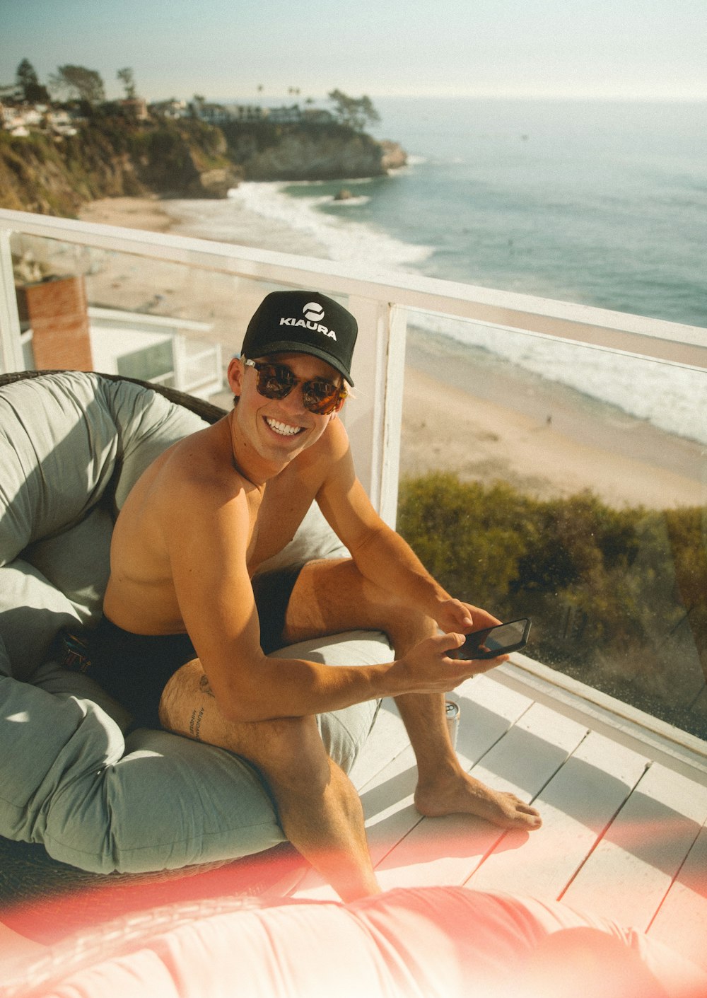 man in black shorts and black sunglasses sitting on white wooden bench