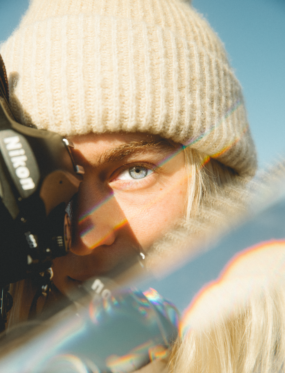 woman in gray knit cap holding black dslr camera