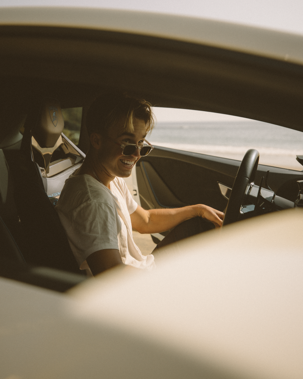 woman in white shirt driving car during daytime