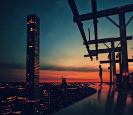 silhouette of man standing on bridge during night time