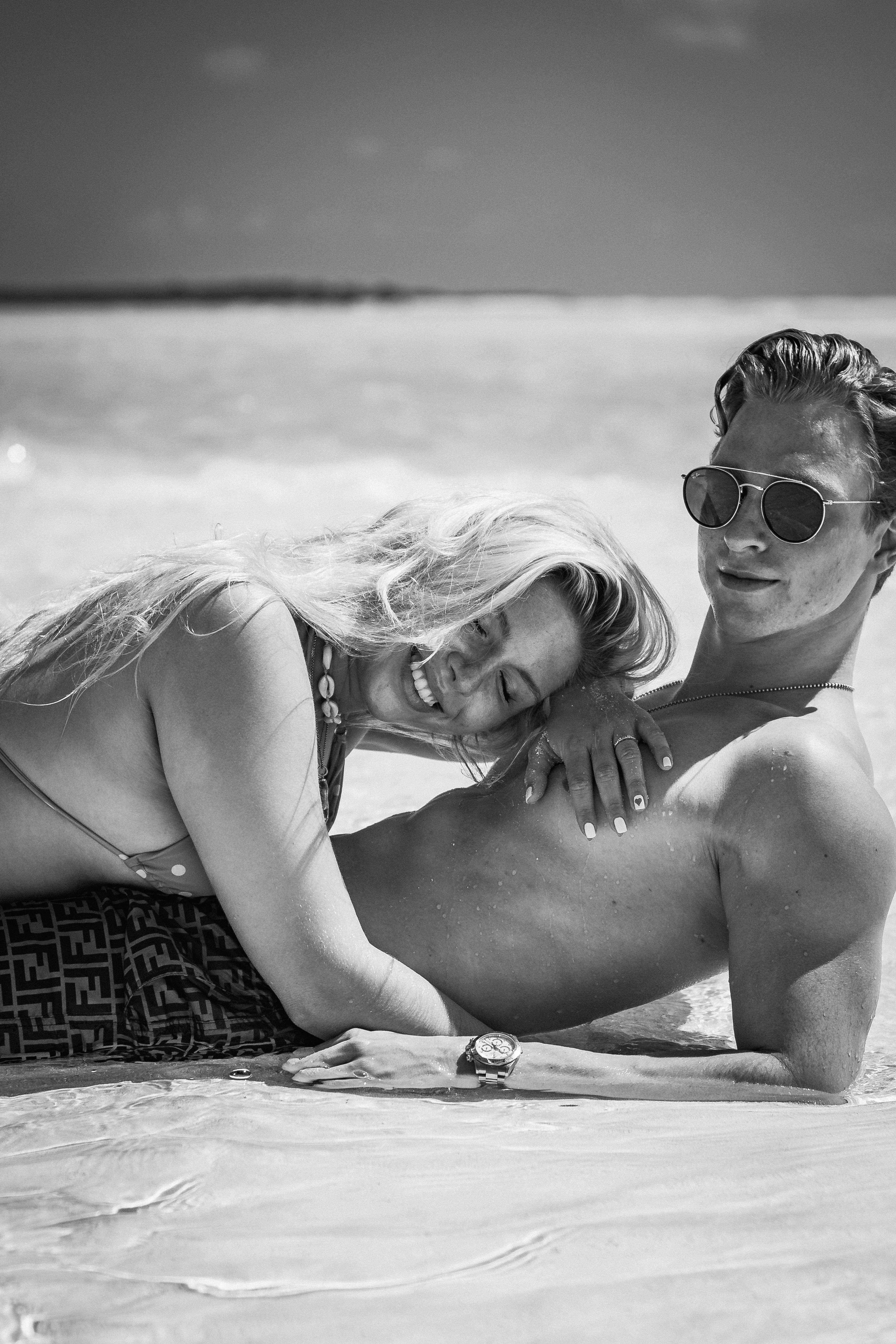 Topless woman wearing sunglasses lying on beach photo