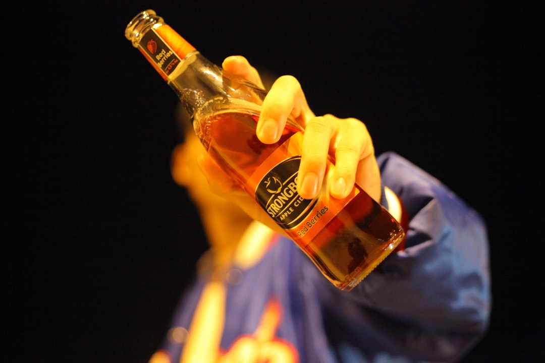 person holding brown glass bottle