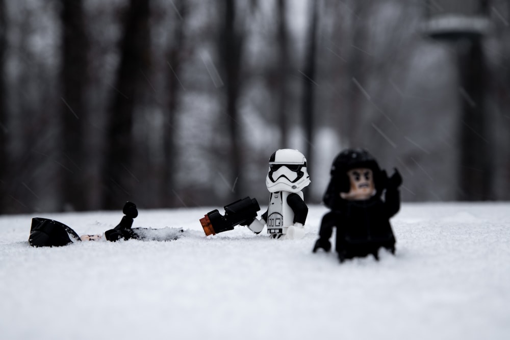 2 children playing on snow covered ground during daytime