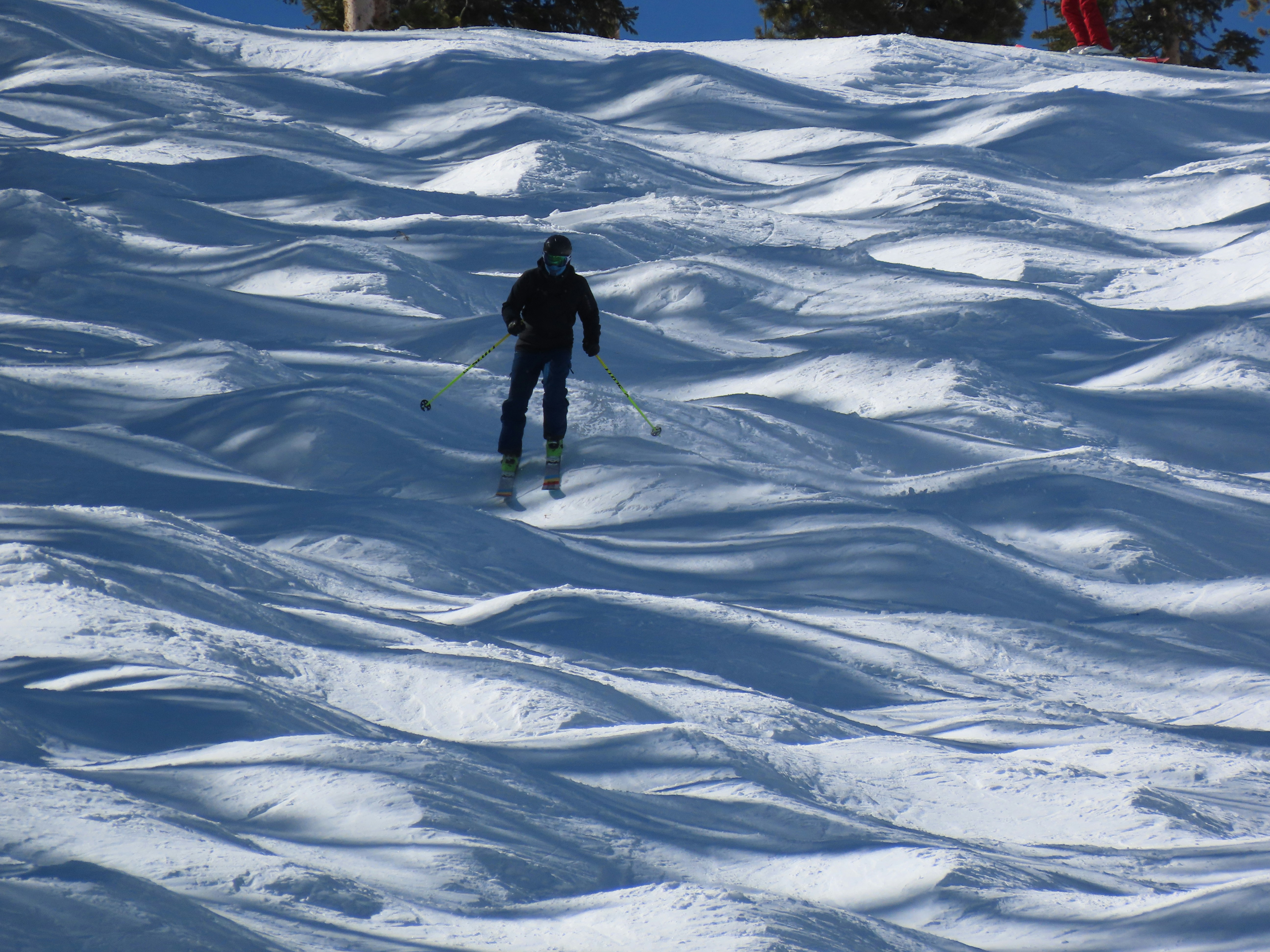 person in black jacket walking on snow covered ground during daytime