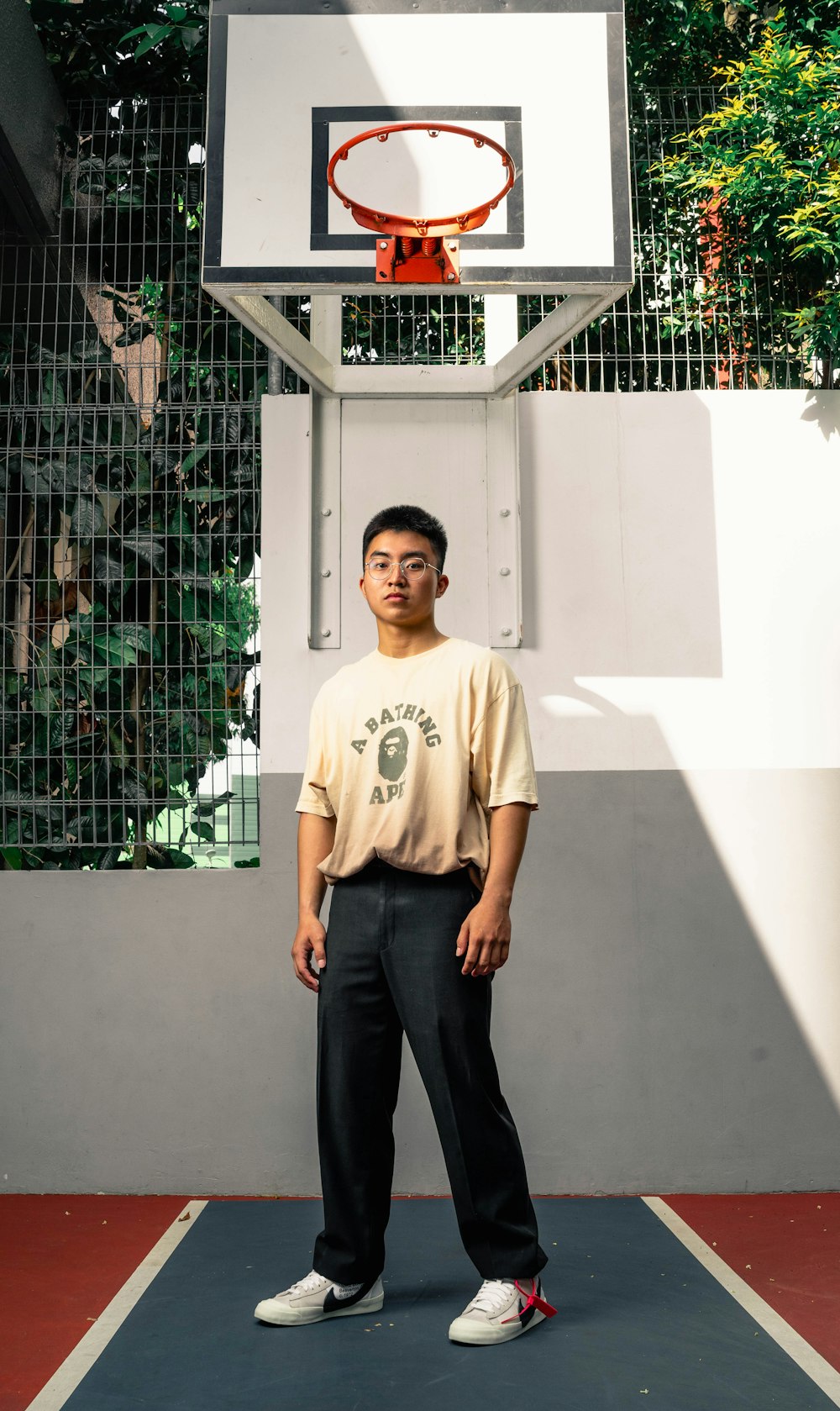 woman in yellow crew neck t-shirt and black pants standing beside white metal fence during