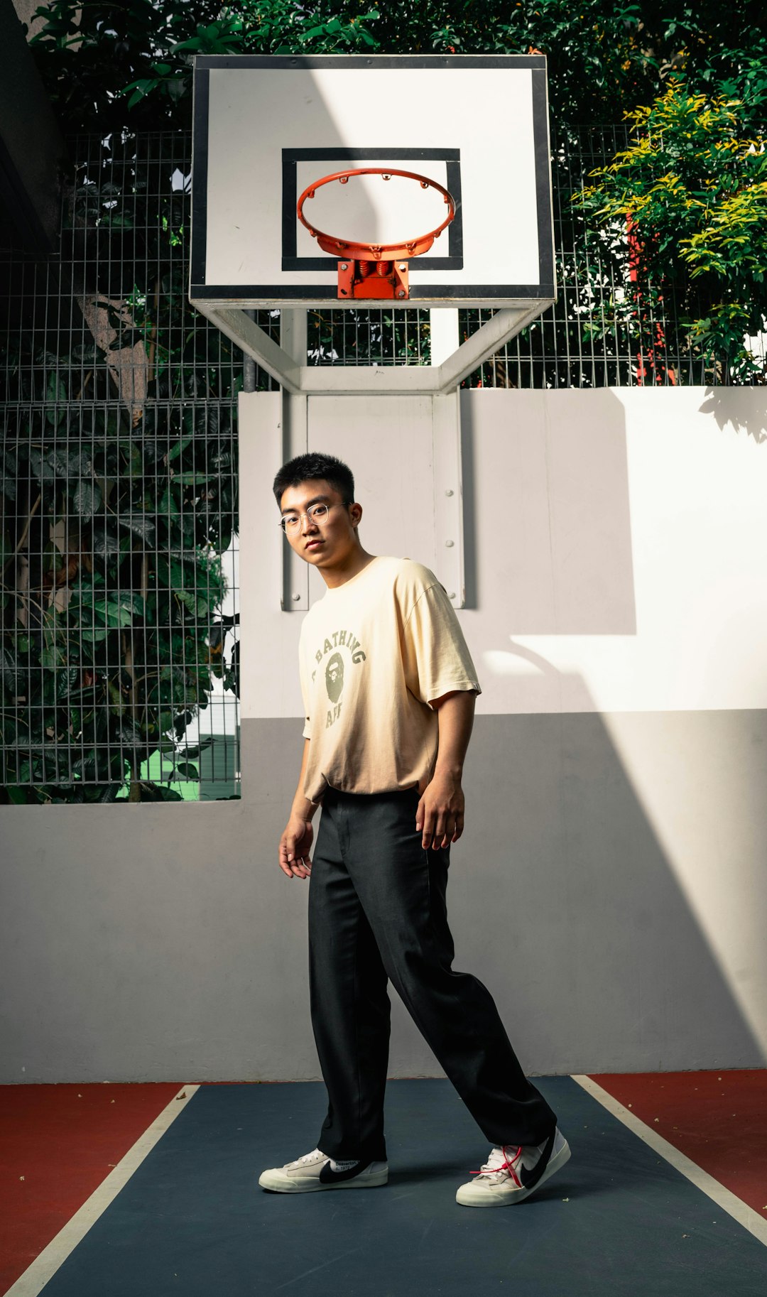 man in white crew neck t-shirt and black pants standing near white wall