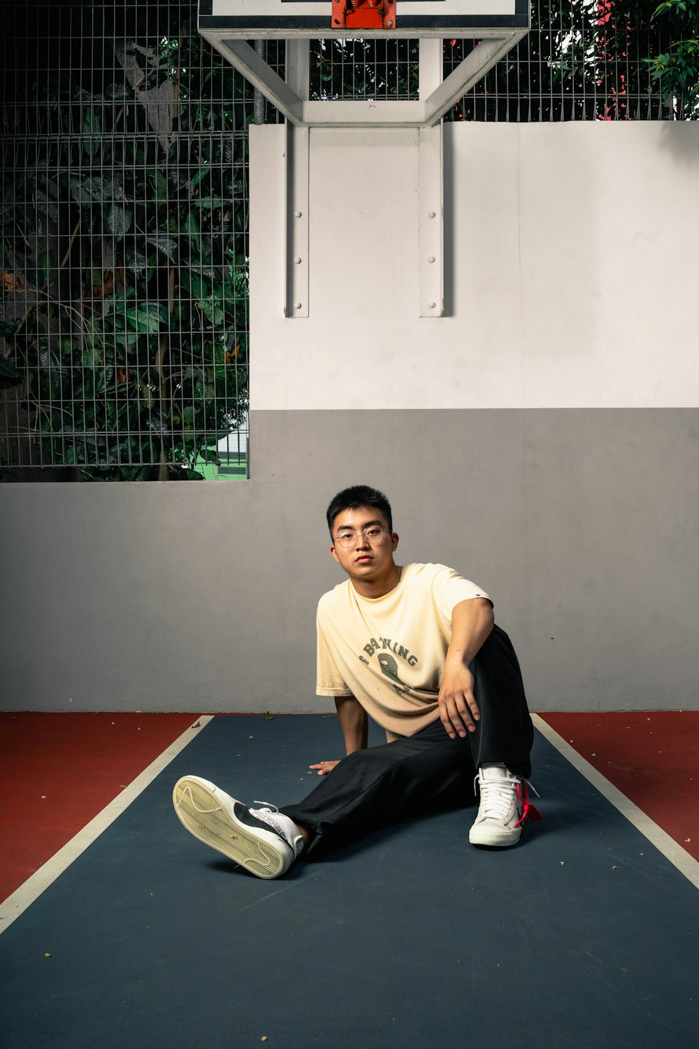 man in yellow crew neck t-shirt and black pants sitting on red floor