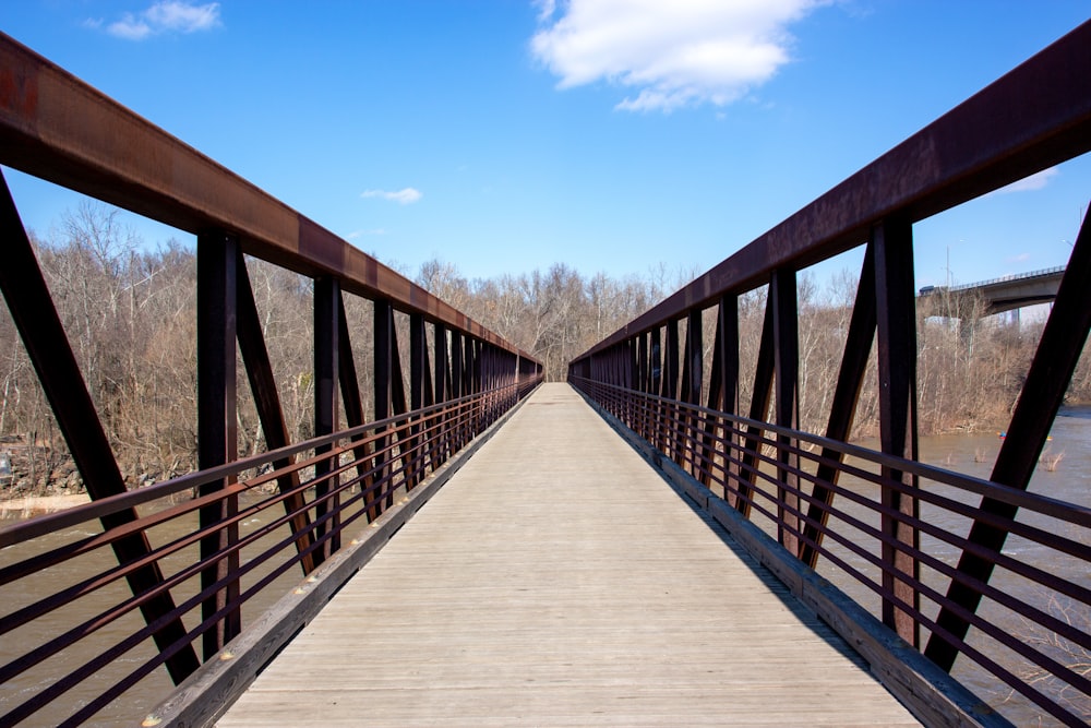 brown wooden bridge under blue sky during daytime