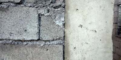 Before and after shot of a concrete wall cleaned by laser, showing clear difference