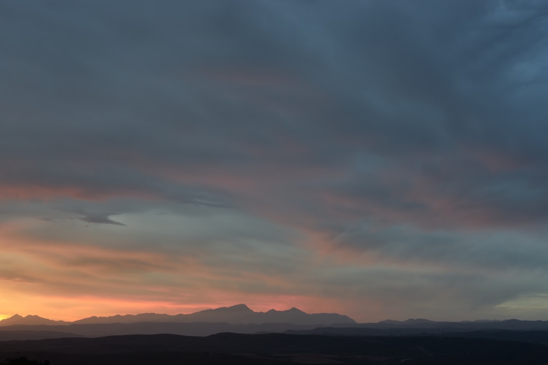 silhouette of mountains under cloudy sky during daytime