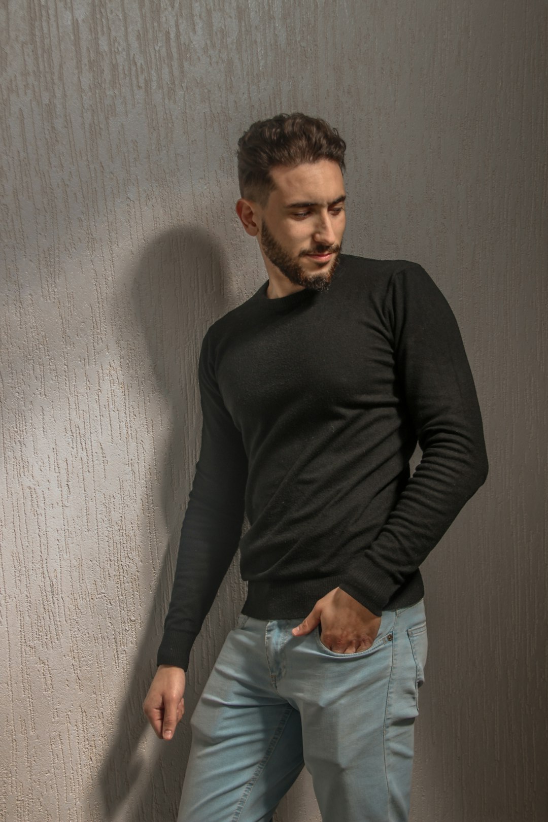 man in black long sleeve shirt and blue denim jeans