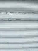 A metal surface featuring horizontal lines with visible peeling and chipping paint, creating a textured appearance.