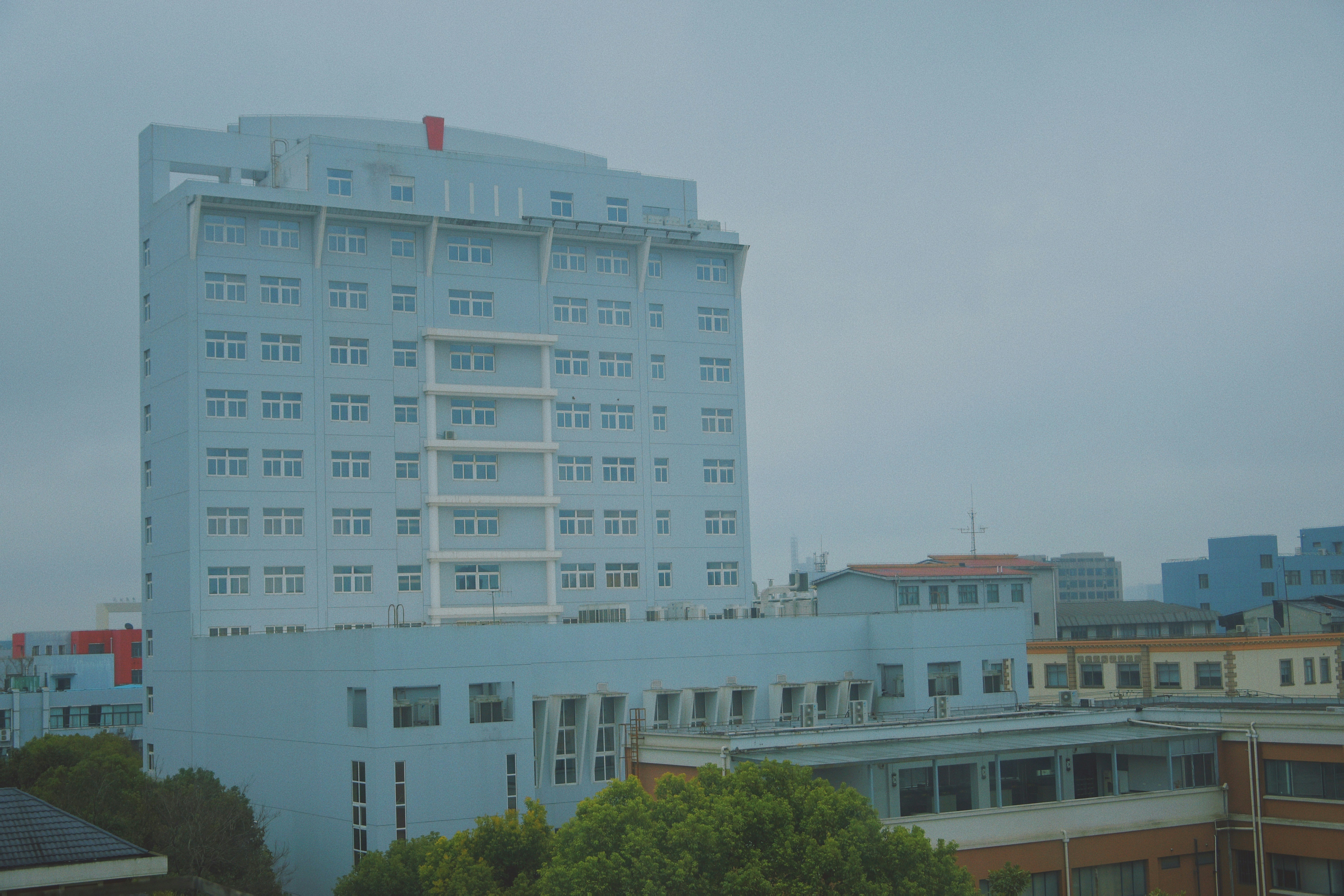 white concrete building near green trees during daytime